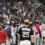 
              Fans stand as the benches clear after Chicago White Sox's Andrew Vaughn (25) was hit by pitch from Minnesota Twins reliever Jorge Lopez during the ninth inning of a baseball game in Chicago, Friday, Sept. 2, 2022. The White Sox won 4-3. (AP Photo/Nam Y. Huh)
            
