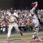 
              San Francisco Giants' LaMonte Wade Jr., left, scores past Philadelphia Phillies catcher J.T. Realmuto during the third inning of a baseball game in San Francisco, Saturday, Sept. 3, 2022. (AP Photo/Jeff Chiu)
            