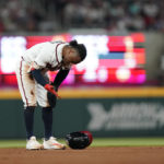
              Atlanta Braves' Ozzie Albies looks at his hand after he slid in safely against Philadelphia Phillies second baseman Jean Segura in the fourth inning of a baseball game, Saturday, Sept. 17, 2022, in Atlanta. (AP Photo/Brynn Anderson)
            