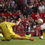 
              Manchester United's Antony, right, scores his side's opening goal past Arsenal's goalkeeper Aaron Ramsdale during the English Premier League soccer match between Manchester United and Arsenal at Old Trafford stadium, in Manchester, England, Sunday, Sept. 4, 2022. (AP Photo/Dave Thompson)
            