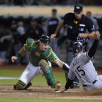 
              Oakland Athletics catcher Sean Murphy, left, tries to tag Chicago White Sox's Adam Engel (15), who scored the tying run during the ninth inning of a baseball game in Oakland, Calif., Friday, Sept. 9, 2022. (AP Photo/Godofredo A. Vásquez)
            