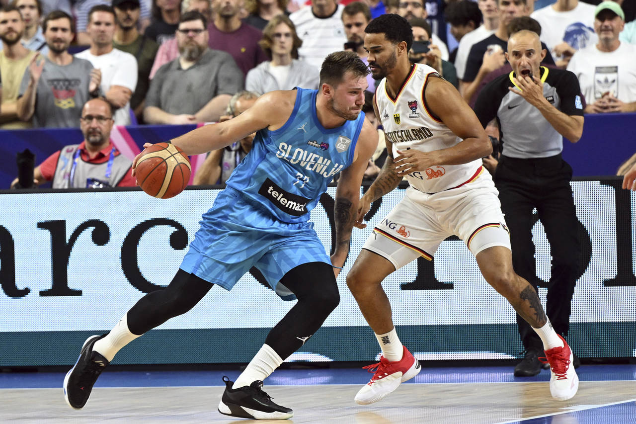 Germany's Nick Weiler-Babb and Slovenia's Luka Doncic, left, fight for the ball during the Eurobask...
