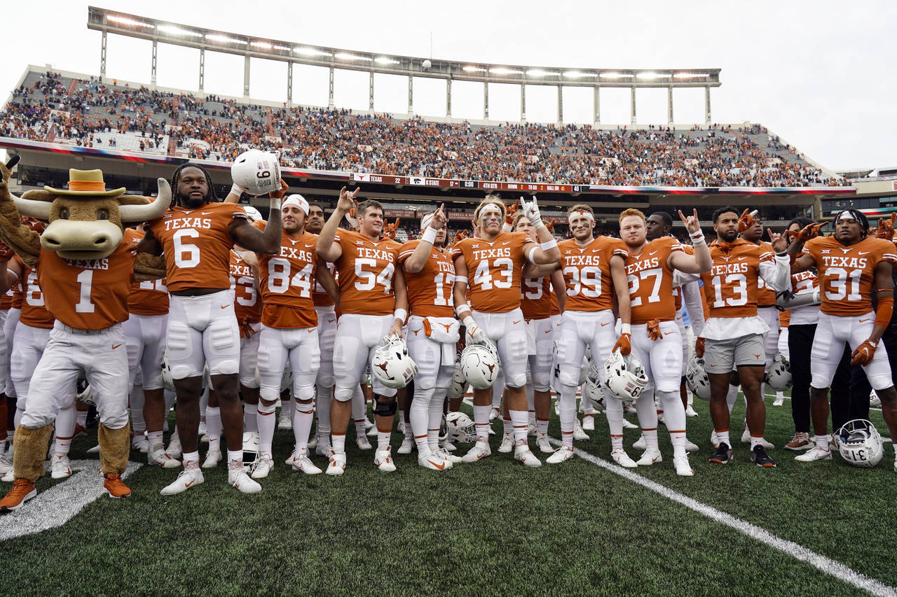FILE - Texas players sing "The Eyes Of Texas," after defeating Kansas State 22-17 in an NCAA colleg...