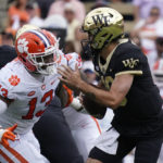 
              Wake Forest quarterback Sam Hartman (10) looks to pass as Clemson defensive tackle Tyler Davis (13) defends during the first half of an NCAA college football game in Winston-Salem, N.C., Saturday, Sept. 24, 2022. (AP Photo/Chuck Burton)
            