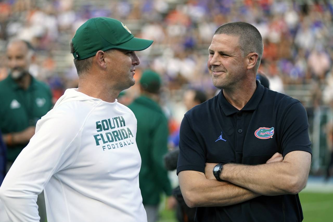 South Florida head coach Jeff Scott, left, and Florida head coach Billy Napier greet each other at ...