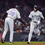 
              Colorado Rockies' Alan Trejo, right, celebrates with third base coach Stu Cole after hitting a solo home run against the San Francisco Giants during the fifth inning of a baseball game in San Francisco, Wednesday, Sept. 28, 2022. (AP Photo/Godofredo A. Vásquez)
            
