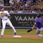 
              Colorado Rockies' Yonathan Daza, right, is forced out at second by Los Angeles Dodgers second baseman Gavin Lux as Lux throws out Jose Iglesias at first during the first inning of a baseball game Friday, Sept. 30, 2022, in Los Angeles. (AP Photo/Mark J. Terrill)
            