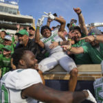 
              Marshall players and fans celebrate after defeating Notre Dame 26-21 in an NCAA college football game Saturday, Sept. 10, 2022, in South Bend, Ind. Marshall won 26-21. (Sholten Singer/The Herald-Dispatch via AP)
            