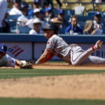 
              Arizona Diamondbacks' Josh Rojas, right, dives safely into third as Los Angeles Dodgers' Trea Turner waits for the throw during the fifth inning of a baseball game Tuesday, Sept 20, 2022, in Los Angeles. (AP Photo/Ringo H.W. Chiu)
            