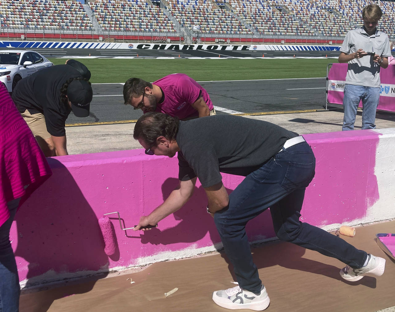 NASCAR driver Kurt Busch, foreground, helps paint the pit wall pink during 10th annual recognition ...