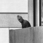 
              FILE - A member of the Arab Commando group which seized members of the Israeli Olympic Team at their quarters at the Olympic Village appearing with a hood over his face stands on the balcony of the building where the commandos held members of the Israeli team hostage in Munich, Sept. 5, 1972. The families of 11 Israeli athletes killed by Palestinian attackers at the 1972 Summer Olympics in Munich and the German government are close to reaching a deal over the long-disputed amount of the compensation. (AP Photo/Kurt Strumpf, File)
            