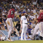 
              Arizona Diamondbacks' Daulton Varsho, right, and Geraldo Perdomo, left, score on a three RBI double by Corbin Carroll while Jake McCarthy, second from left, congratulate them as Los Angeles Dodgers starting pitcher Dustin May, second from right, stands in the background during the fourth inning of a baseball game Wednesday, Sept. 21, 2022, in Los Angeles. (AP Photo/Mark J. Terrill)
            