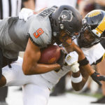 
              Oklahoma State wide receiver Bryson Green (9) struggles forward while being tackled by Arkansas-Pine Bluff defensive back Nathan Seward during the first half of an NCAA college football game, Saturday, Sept. 17, 2022, in Stillwater, Okla. (AP Photo/Brody Schmidt)
            