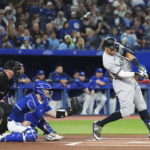 
              New York Yankees' Aaron Judge lines out to third as Toronto Blue Jays catcher Alejandro Kirk watches  during the first inning of a baseball game Tuesday, Sept. 27, 2022, in Toronto. (Nathan Denette/The Canadian Press via AP)
            