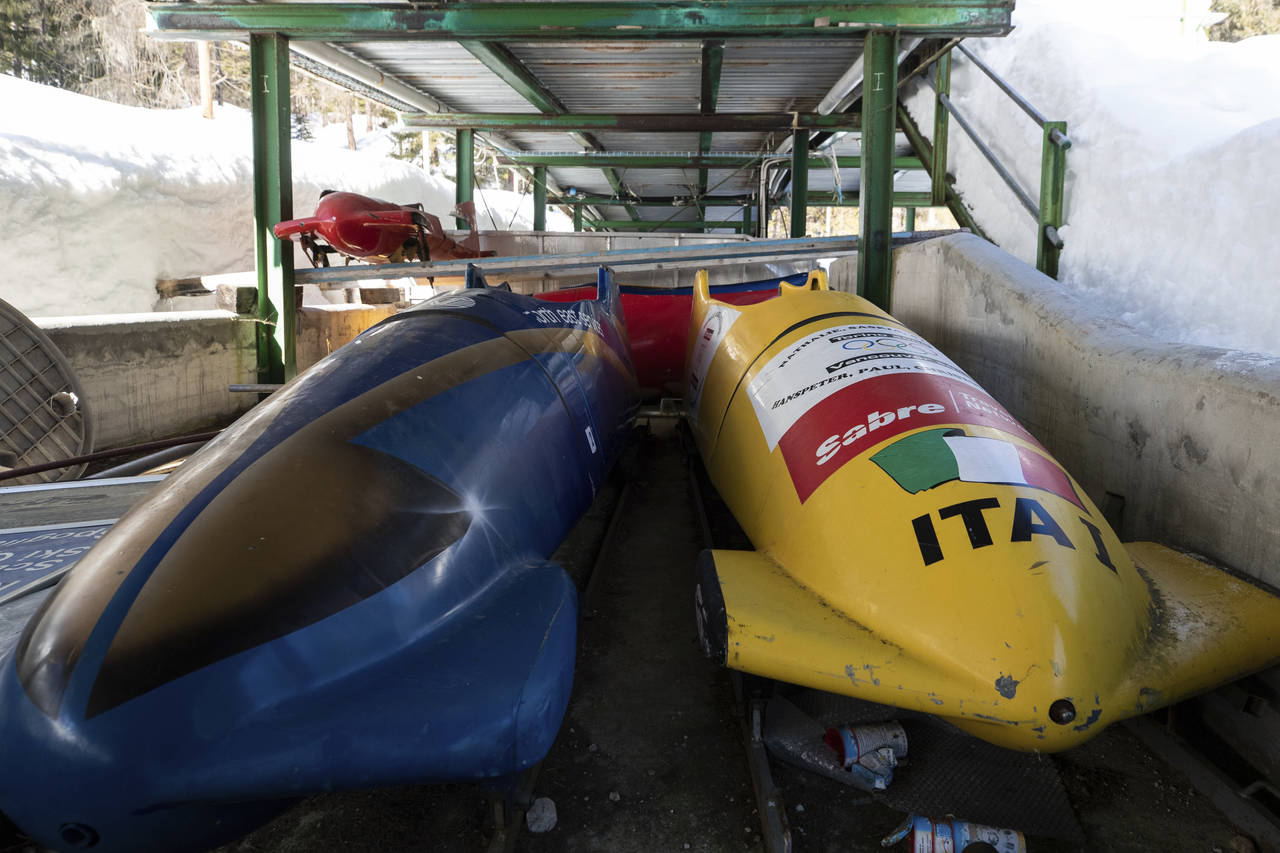 FILE - Bobsleds are parked next to the track in Cortina d'Ampezzo, Italy, on Feb. 17, 2021. Costly ...