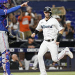 
              Miami Marlins' Charles Leblanc, right, scores past Texas Rangers catcher Jonah Heim, left, on a single hit by Jon Berti in the fifth inning during Game 2 of a doubleheader baseball game, Monday, Sept. 12, 2022, in Miami. (AP Photo/Lynne Sladky)
            