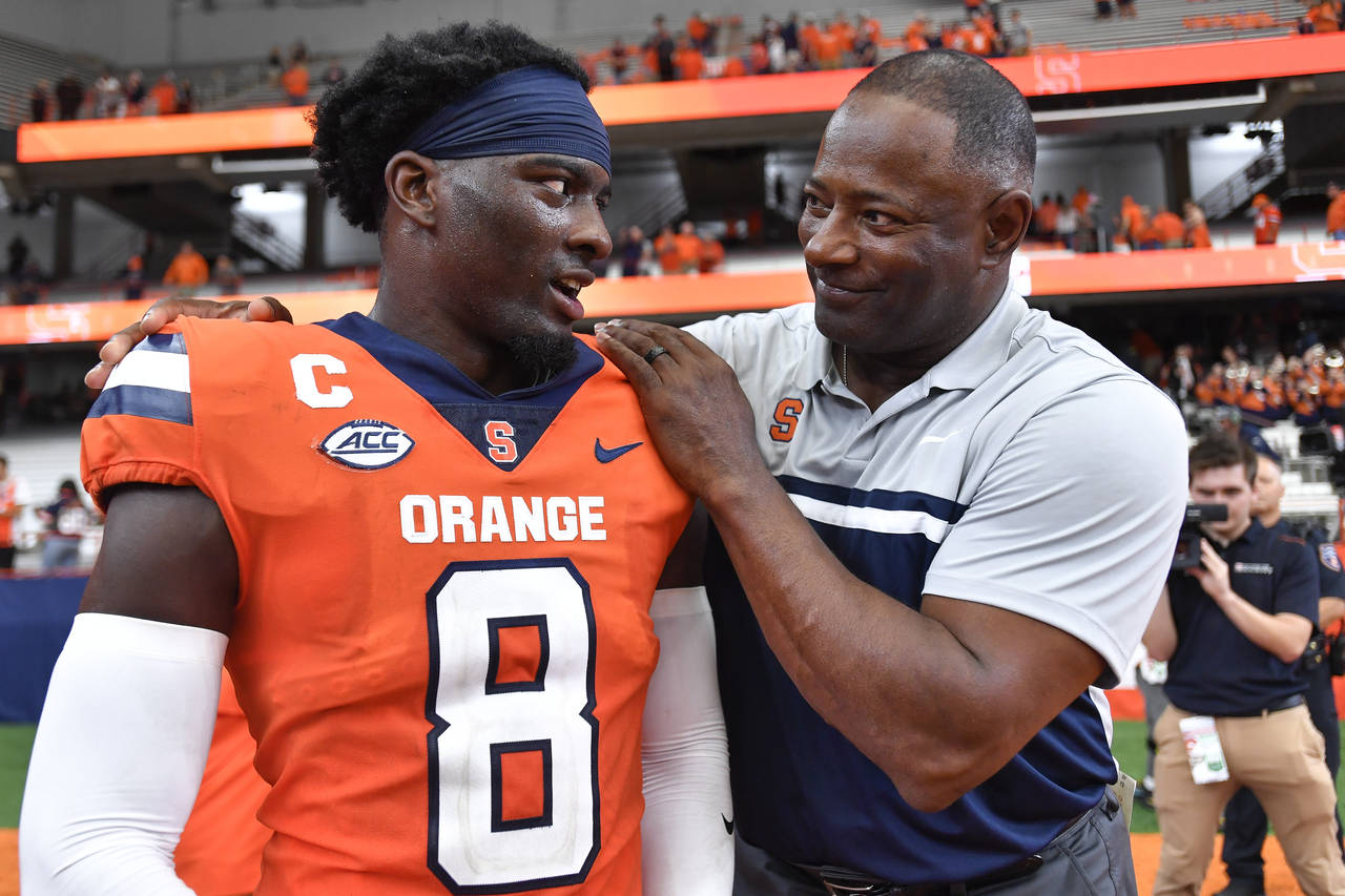 Syracuse head coach Dino Babers, right, celebrates with defensive back Garrett Williams after defea...