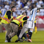 
              A fan is tackled as he tries to take a selfie with Argentina's player Lionel Messi as he celebrates his goal during the second half of an international friendly soccer match against Jamaica on Tuesday, Sept. 27, 2022, in Harrison, N.J. (AP Photo/Eduardo Munoz Alvarez)
            