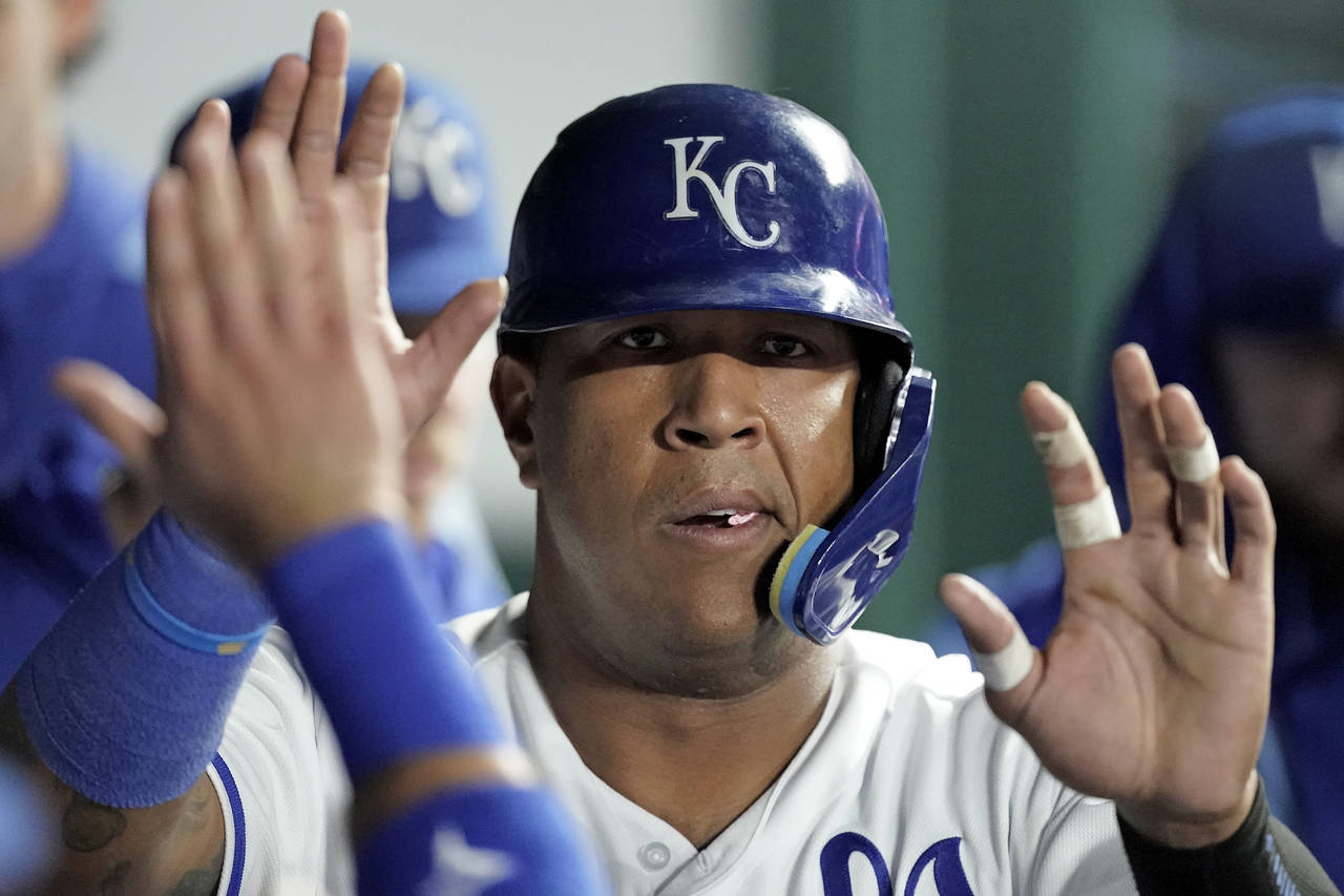 Kansas City Royals' Salvador Perez celebrates in the dugout after scoring on a single by Edward Oli...