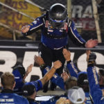 
              Chris Buescher jumps from the top of his car to the arms of his crew after winning a NASCAR Cup Series auto race at Bristol Motor Speedway Saturday, Sept. 17, 2022, in Bristol, Tenn. (AP Photo/Mark Humphrey)
            