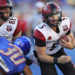 
              San Diego State quarterback Braxton Burmeister (5) runs around the block by tight end Mark Redman (81) on Boise State linebacker Isaiah Bagnah (30) during the first half of an NCAA college football game Friday, Sept. 30, 2022, in Boise, Idaho. (AP Photo/Steve Conner)
            
