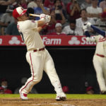 
              Los Angeles Angels' Mike Trout, left, hits a solo home run as Shohei Ohtani practice swings during the fifth inning of a baseball game against the Seattle Mariners Friday, Sept. 16, 2022, in Anaheim, Calif. (AP Photo/Mark J. Terrill)
            