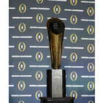 
              FILE - The national championship trophy is seen before a new conference for the NCAA college football playoff championship game between Clemson and Alabama, Sunday, Jan. 10, 2016, in Glendale, Ariz. The university presidents who oversee the College Football Playoff voted Friday, Sept. 2, 2022, to expand the postseason model for determining a national champion from four to 12 teams no later than the 2026 season.(AP Photo/David J. Phillip, File)
            