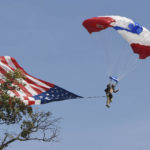 
              The American flag gets snagged by a tree as a member of the Frog-X Navy Seal Parachute team safely lands near the 18th green during the second round of the LIV Golf Invitational-Chicago tournament Saturday, Sept. 17, 2022, in Sugar Grove, Ill. (Joe Lewnard/Daily Herald via AP)
            