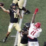 
              Wake Forest quarterback Sam Hartman (10) looks to pass over Liberty defensive end Durrell Johnson (11) during the first half of an NCAA college football game in Winston-Salem, N.C., Saturday, Sept. 17, 2022. (AP Photo/Chuck Burton)
            