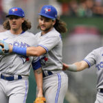 
              Toronto Blue Jays starting pitcher Kevin Gausman, left, is restrained by shortstop Bo Bichette, center, and second baseman Cavan Biggio after Gausman was called for a balk by second base umpire Jeff Nelson during the fourth inning of the first game of a baseball doubleheader against the Baltimore Orioles, Monday, Sept. 5, 2022, in Baltimore. (AP Photo/Julio Cortez)
            
