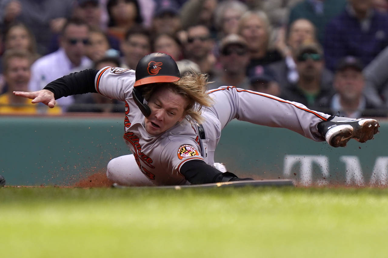 Baltimore Orioles' Kyle Stowers slides safe at home after Orioles' Adley Rutschman grounded out in ...