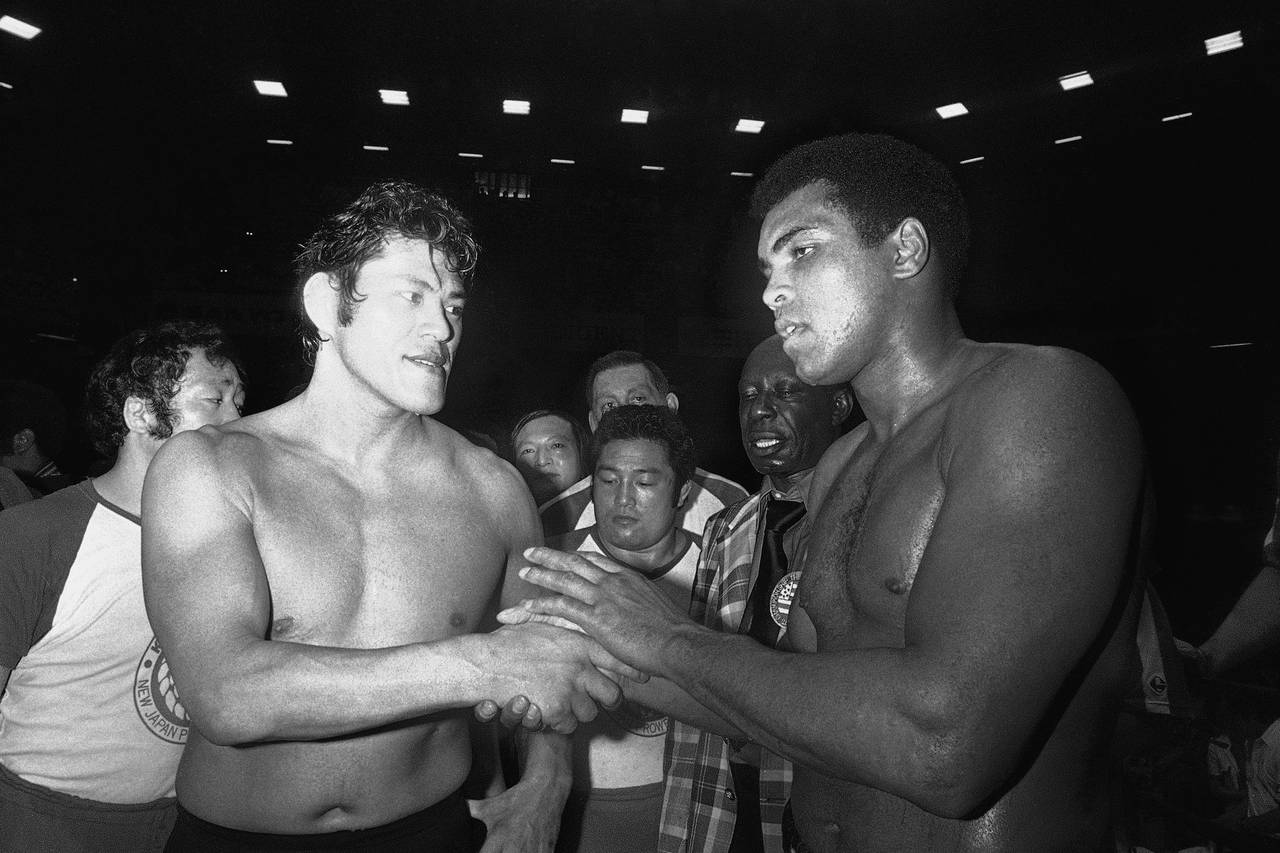FILE - Wrestler Antonio Inoki, left, and world heavyweight boxing champion Muhammad Ali shake hands...