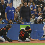 
              Baltimore Orioles catcher Adley Rutschman, left, starting pitcher Jordan Lyles (28) and third baseman Ramon Urias are unable to chase down a foul ball hit by Toronto Blue Jayss Cavan Biggio during the fourth inning of a baseball game Friday, Sept. 16, 2022, in Toronto. (Jon Blacker/The Canadian Press via AP)
            