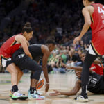 
              Las Vegas Aces guard Kelsey Plum (10) grabs Seattle Storm guard Jewell Loyd (24) as center Tina Charles (31) looks on while players go for a loose ball during the first half of Game 4 of a WNBA basketball playoff semifinal Tuesday, Sept. 6, 2022, in Seattle. (AP Photo/Lindsey Wasson)
            