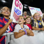 
              Young fans look on as they wait for members of the U.S. Soccer Federation, the U.S. Women's National Team Players Association and the U.S. National Soccer Team Players Association to sign a new collective bargaining agreements following the women's match against Nigeria at Audi Field, Tuesday, Sept. 6, 2022, in Washington. (AP Photo/Julio Cortez)
            