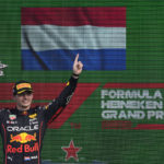 
              Red Bull driver Max Verstappen of the Netherlands lifts his trophy on the podium after winning the Formula One Dutch Grand Prix auto race as third placed Ferrari driver Charles Leclerc of Monaco, right, looks on, at the Zandvoort racetrack, in Zandvoort, Netherlands, Sunday, Sept. 4, 2022. (AP Photo/Peter Dejong)
            