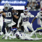 
              Dallas Cowboys running back Tony Pollard (20) tries to avoid a tackle by New York Giants cornerback Darnay Holmes (30) during the second quarter of an NFL football game, Monday, Sept. 26, 2022, in East Rutherford, N.J. (AP Photo/Adam Hunger)
            