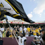 
              Appalachian State defensive back Kaleb Dawson (1) waves his school's flag inside of Kyle Field after upsetting Texas A&M 17-14 in an NCAA college football game Saturday, Sept. 10, 2022, in College Station, Texas. (AP Photo/Sam Craft)
            