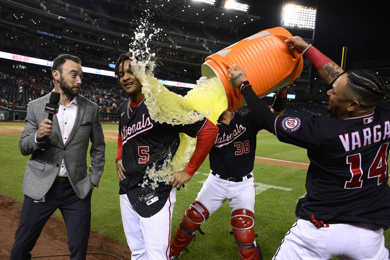 Washington Nationals' CJ Abrams (5) gets doused by Ildemaro Vargas (14) and Tres Barrera (38) after...