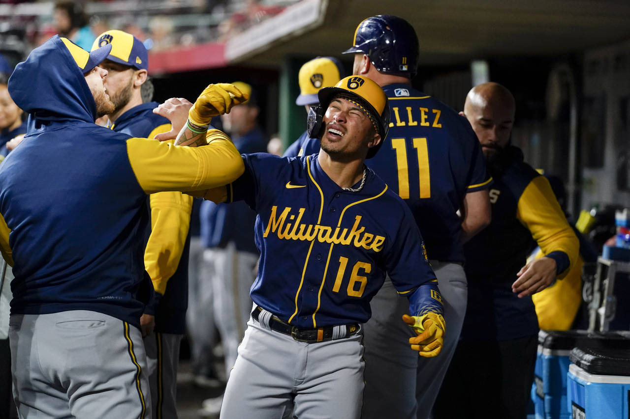 Milwaukee Brewers' Kolten Wong (16) celebrates with teammates in the dugout after his two-run home ...