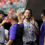 
              Colorado Rockies' C.J. Cron high-fives teammates after scoring a run during the seventh inning of the first game of a baseball doubleheader against the Cincinnati Reds in Cincinnati, Sunday, Sept. 4, 2022. (AP Photo/Aaron Doster)
            