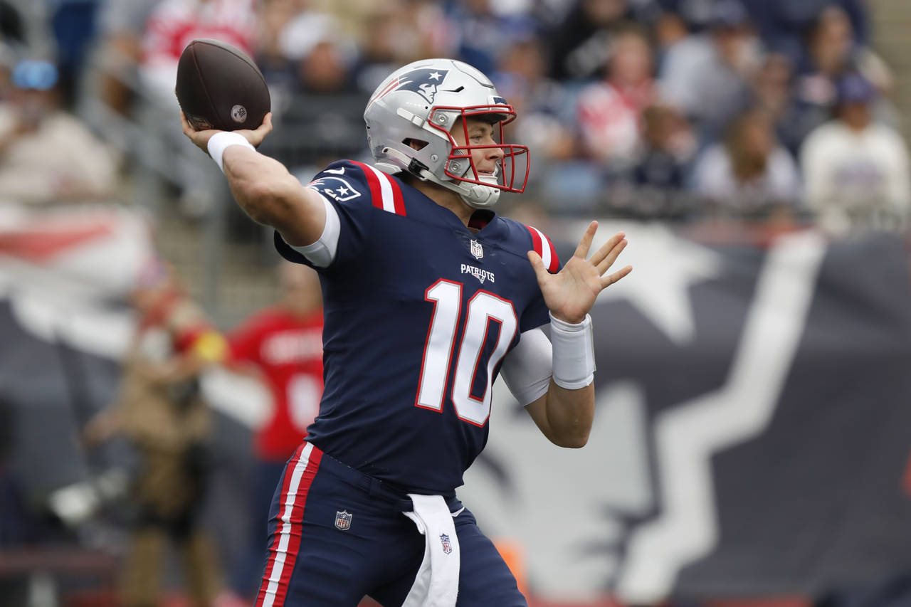 New England Patriots quarterback Mac Jones winds up to pass in the first half of an NFL football ga...