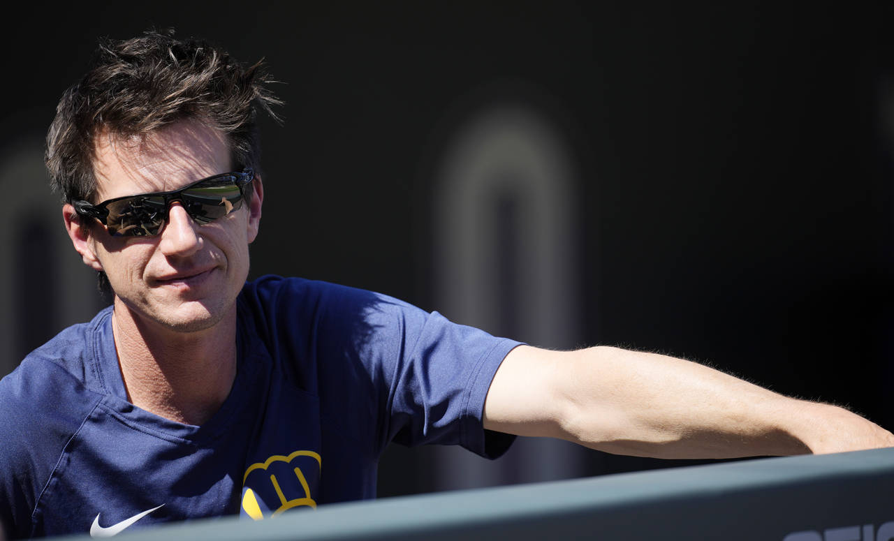 Milwaukee Brewers manager Craig Counsell looks on from the dugout as players warm up before a baseb...