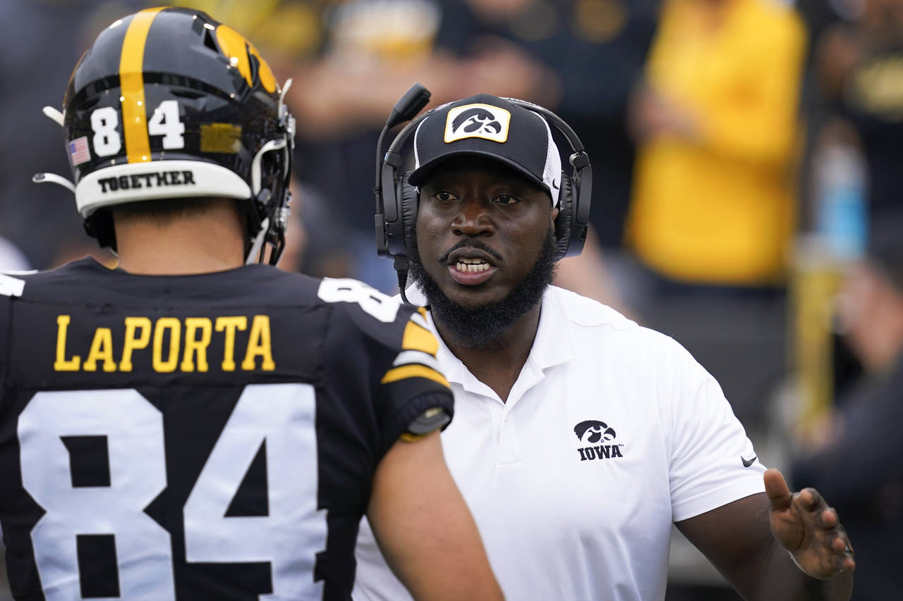 Iowa tight ends coach Abdul Hodge talks with tight end Sam LaPorta (84) before an NCAA college foot...