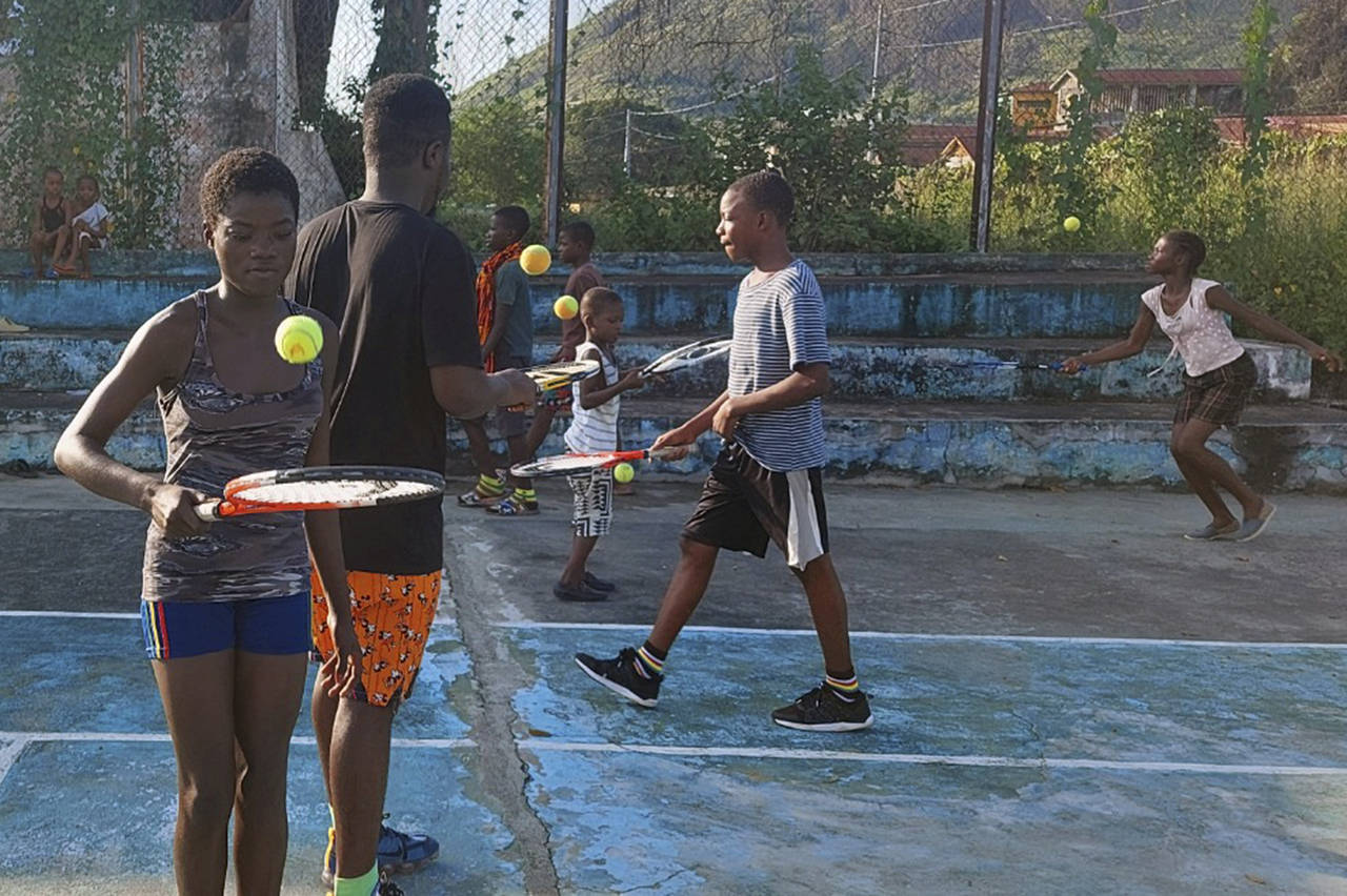 In this photo provided by Sam Jalloh, children in Sierra Leone participate in a tennis lesson in Oc...