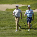 
              Paul Casey, left, and Louis Oosthuizen walk along the fairway to the 13th green following their tee shots during the second round of the LIV Golf Invitational-Boston tournament, Saturday, Sept. 3, 2022, in Bolton, Mass. (AP Photo/Mary Schwalm)
            