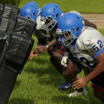 
              Murrah High School football offensive linemen square up against the blocking sled at practice, Wednesday, Aug. 31, 2022, in Jackson, Miss. The city's low water pressure concerns football coach Marcus Gibson, as it limits his options for washing practice uniforms, towels and other gear his players wear. The recent flood worsened Jackson's longstanding water system problems. (AP Photo/Rogelio V. Solis)
            