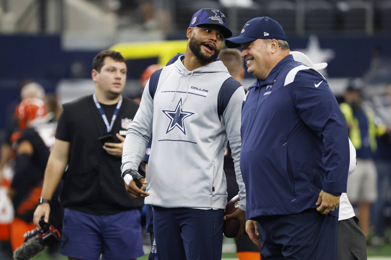 An injured Dallas Cowboys quarterback Dak Prescott, left, talks with head coach Mike McCarthy, righ...
