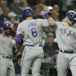 
              Texas Rangers' Josh Jung is greeted by Sam Huff after hitting a solo home run on a pitch from Seattle Mariners starting pitcher Robbie Ray during a baseball game, Tuesday, Sept. 27, 2022, in Seattle. Behind is Renger's Leody Taveras. (AP Photo/John Froschauer)
            