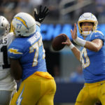 
              Los Angeles Chargers quarterback Justin Herbert, right, passes as Las Vegas Raiders defensive tackle Bilal Nichols (91) applies pressure during the second half of an NFL football game in Inglewood, Calif., Sunday, Sept. 11, 2022. (AP Photo/Gregory Bull)
            